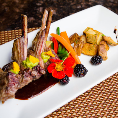 Pan-seared lamb chops with dark reduction sauce and roasted potatoes.