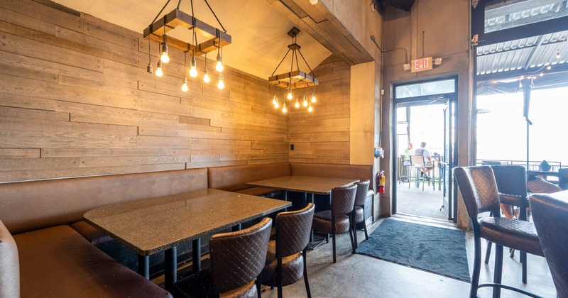 Restaurant interior with wooden walls, leather seating, and granite tables
