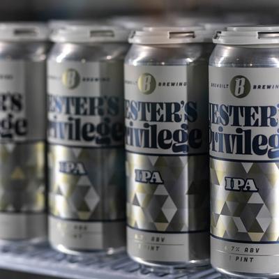 Jester's Privilege IPA cans on a shelf.