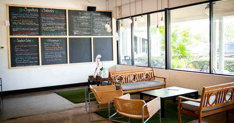 Interior, a coffee table with seating by a window, menu chalkboards on the wall