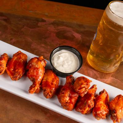 Chicken wings served with ranch dressing and a glass of beer.
