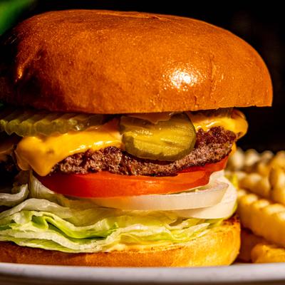 Beelmans burger with cheese, lettuce, tomato, onion and pickles.