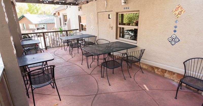 Outdoor patio with metal tables and chairs, a pergola with lights