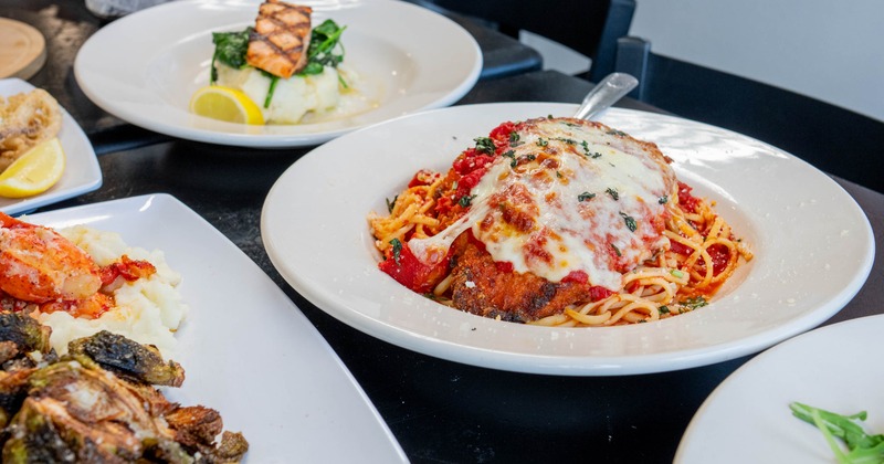 Chicken Parmesan served on the table beside other menu items