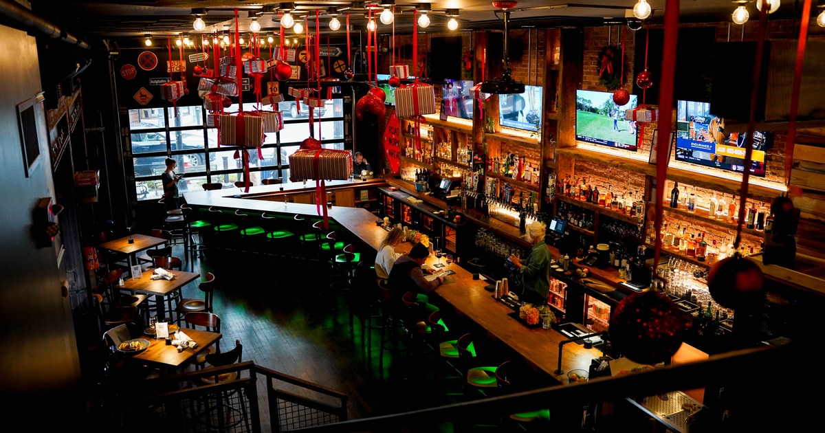 Warmly lit bar interior with hanging ornaments and a large wooden counter