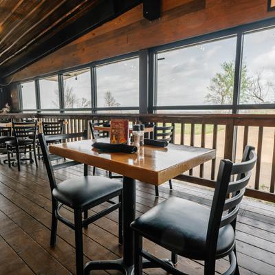 Covered outdoor seating area with picnic tables and benches, and patio heaters.