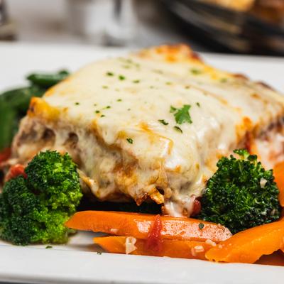 Close up of lasagna and veggies.
