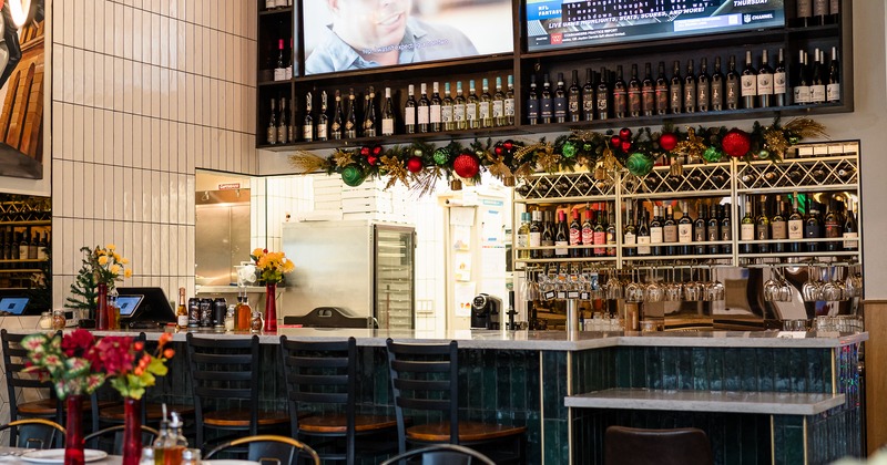 Diner table, bar, drink rack behind, tv screen above