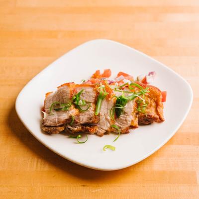 Lechon pork belly sliced with garnish.