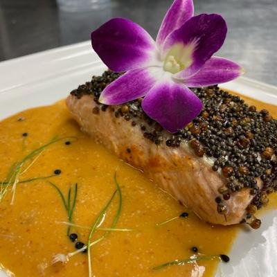 Salmon dish garnished with a purple flower.