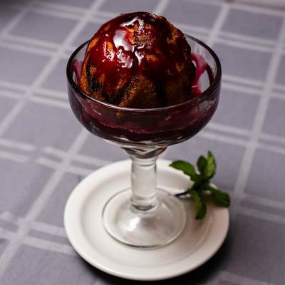 Glass dessert cup with a fried ice cream ball drizzled in rich chocolate sauc.