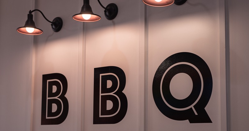 BBQ letters on the wall, illuminated by lamps