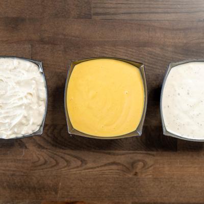 Sauce trio featuring three distinct creamy dipping sauces, overhead view.
