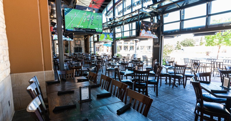 Outside, covered seating area, with TVs, tables and chairs