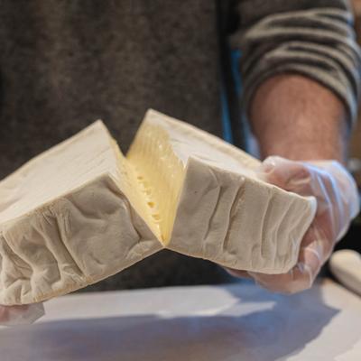 Employee splitting a wedge of cheese.