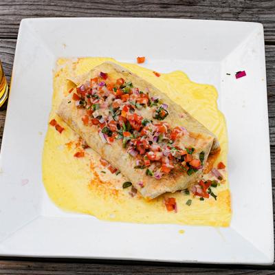 Burrito with creamy sauce and salsa.