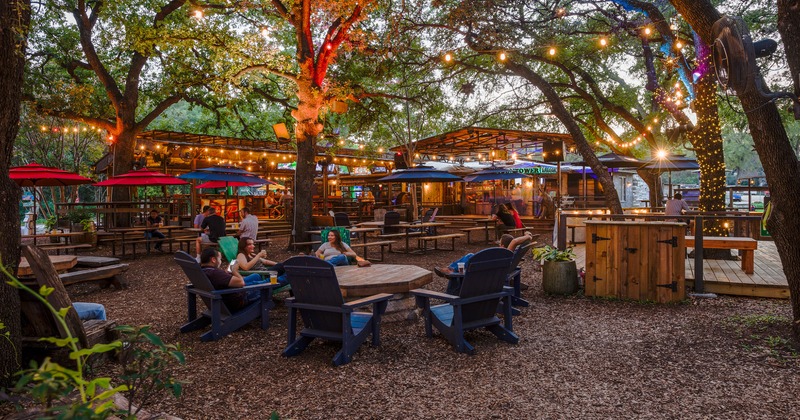 Guests sitting in the outdoor seating area with lots of trees