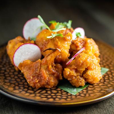 Spiced cauliflower with sauces and ginger, decorated with radish and herbs