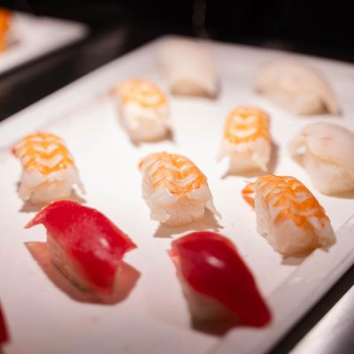 Assorted nigiri sushi rolls on a rectangular plate.