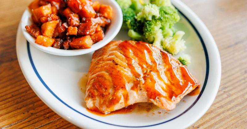 Glazed salmon served with sides of broccoli and sweet potatoes