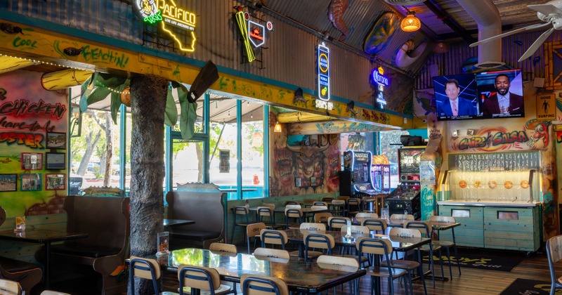 A surf-themed interior - wooden tables, neon signs and colorful graffiti art.