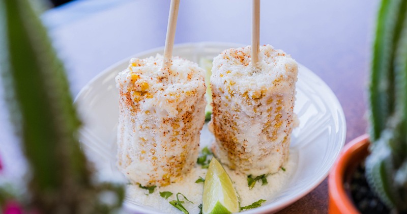 Mexican street corn on the cob, plated with a lime wedge