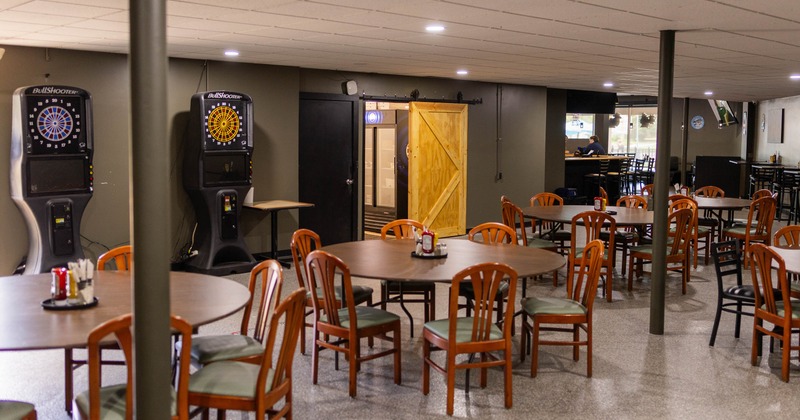 Interior, tables and chairs with dart game machines in the back
