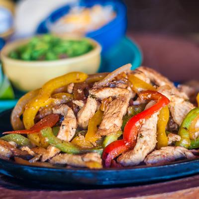 Chicken fajitas with bell peppers and onions, served