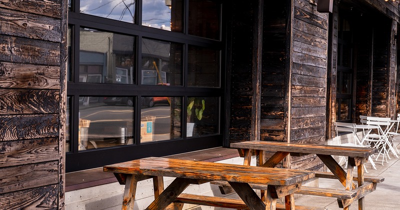 Outdoor seating area, conjoined wooden tables and benches