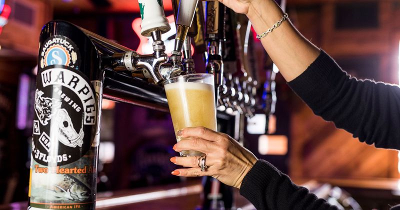 Staff member pouring beer from a tap