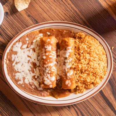 Enchiladas, served with rice, and refried beans.
