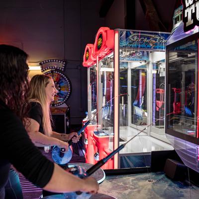 Guests playing a fishing arcade game.