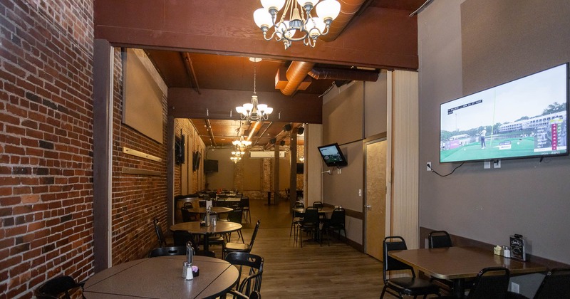 Interior, seating space, tables for four, big TV's on the wall