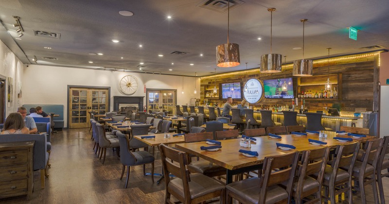 Interior, long tables and chairs ready for guests, bar on the right side