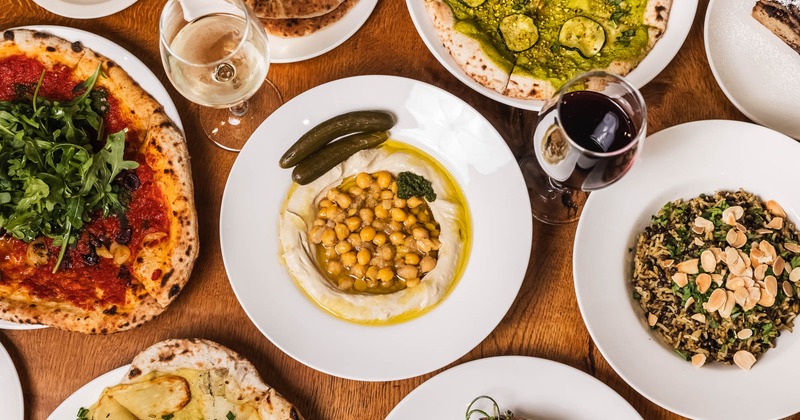 Assorted dishes on a wooden table, and glasses of white and red wine