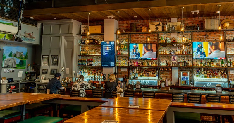 Seating area, tables with barstools and a bar