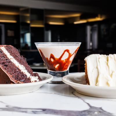 Two different cakes abd a cocktail served on the table.