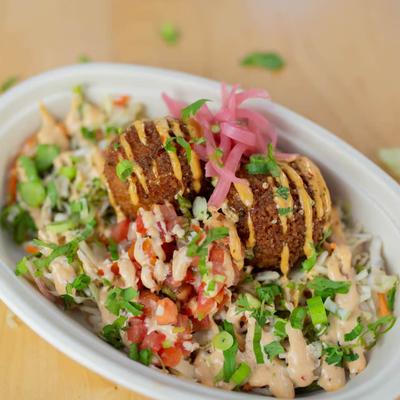 Two crisp falafel balls over a vibrant salad.