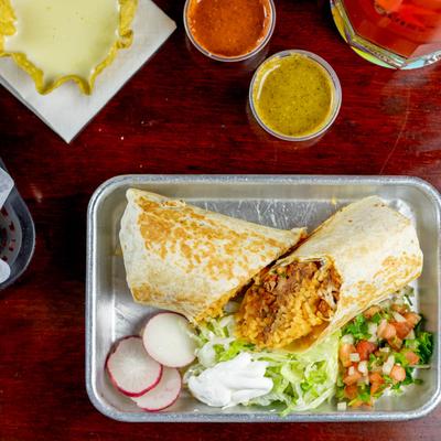 Burrito on plate with vegetables on side, top view