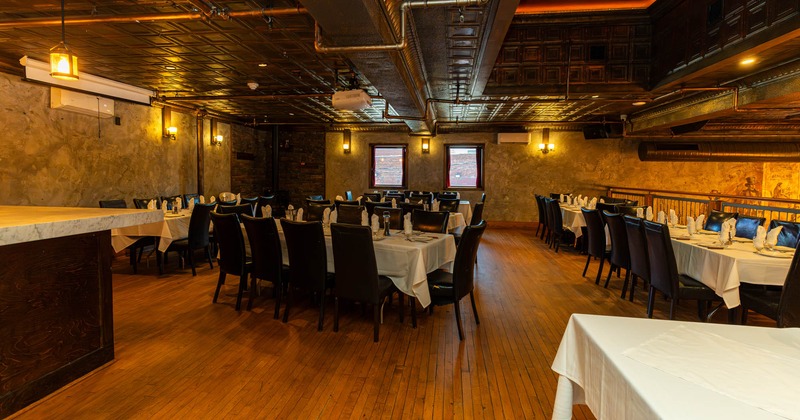 Interior, upstairs dining area, white cloth tables for eight and ten people, hardwood floor