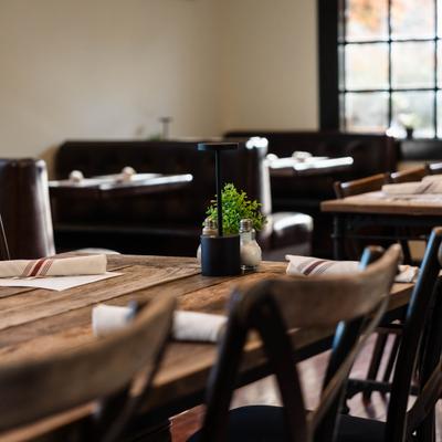 A cozy restaurant featuring wooden tables and chairs arranged for dining.
