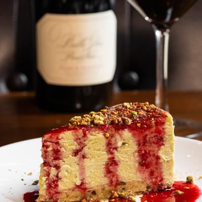 Pistachio cheesecake with a glass of red vine.