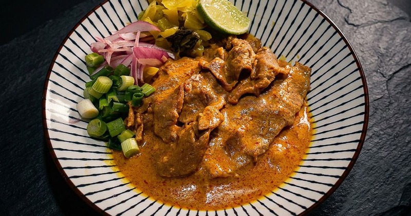 Braised beef with pickled vegetables and green onions on a plate