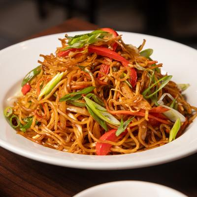 A plate of stir-fried noodles with vegetables.