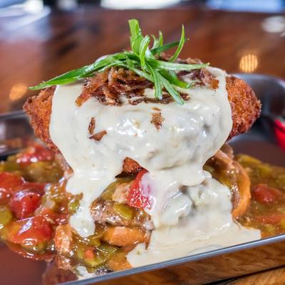 Patty in green chile with mac and cheese, with queso, bacon, and green onion.