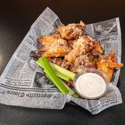 Garlic Parmesan Wings served with celery sticks and a dipping sauce.