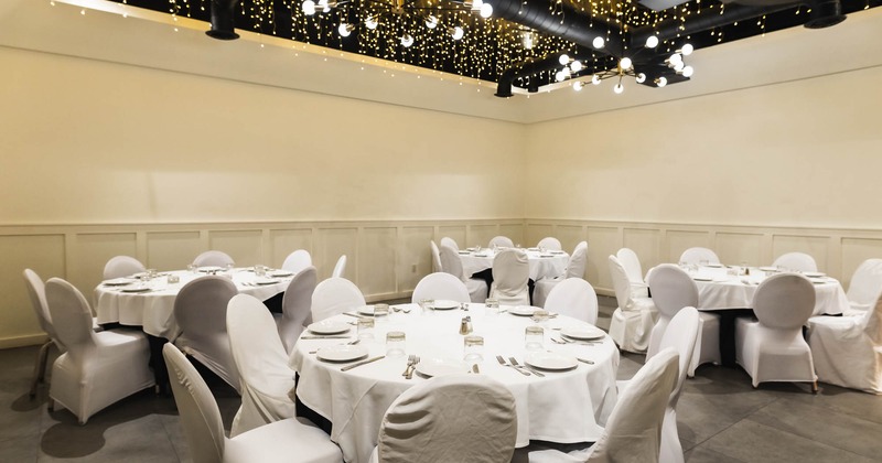 Interior, round tables with white tablecloths and chairs