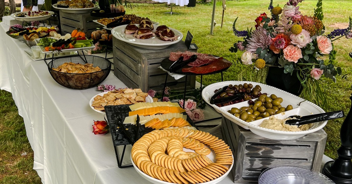 Outdoor catering buffet set up featuring a variety of appetizers and finger food