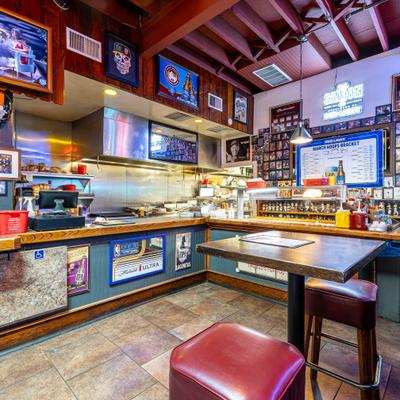 Cozy diner with sports-themed decor, showcasing memorabilia and TV screens.