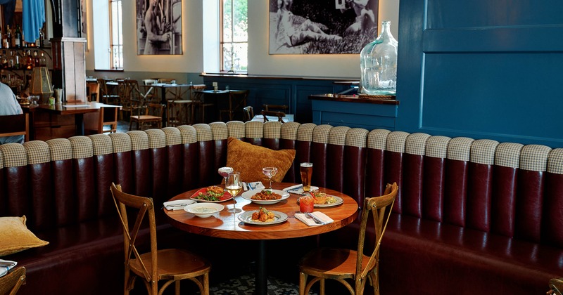 Interior, dining area, banquette seating in front, regular seating in he back, set up table